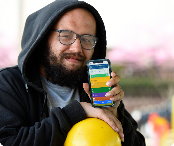 A Man holding mobile showcasing the MYRIDERCATA App