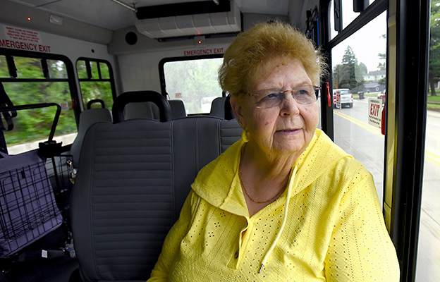 A woman sitting on a Redi-Ride bus, looking out the window