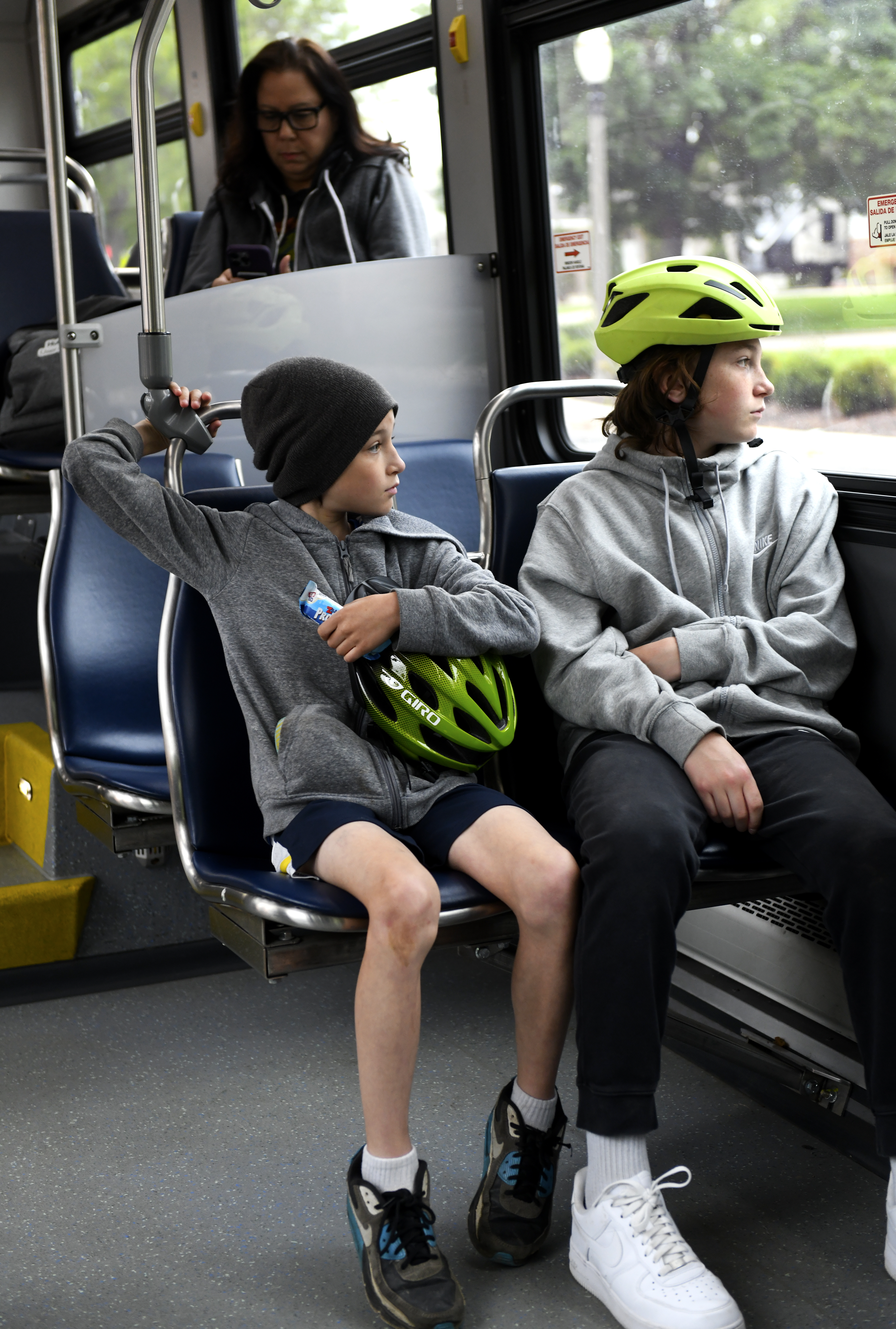 Two students sitting on CATA bus with bike helmets