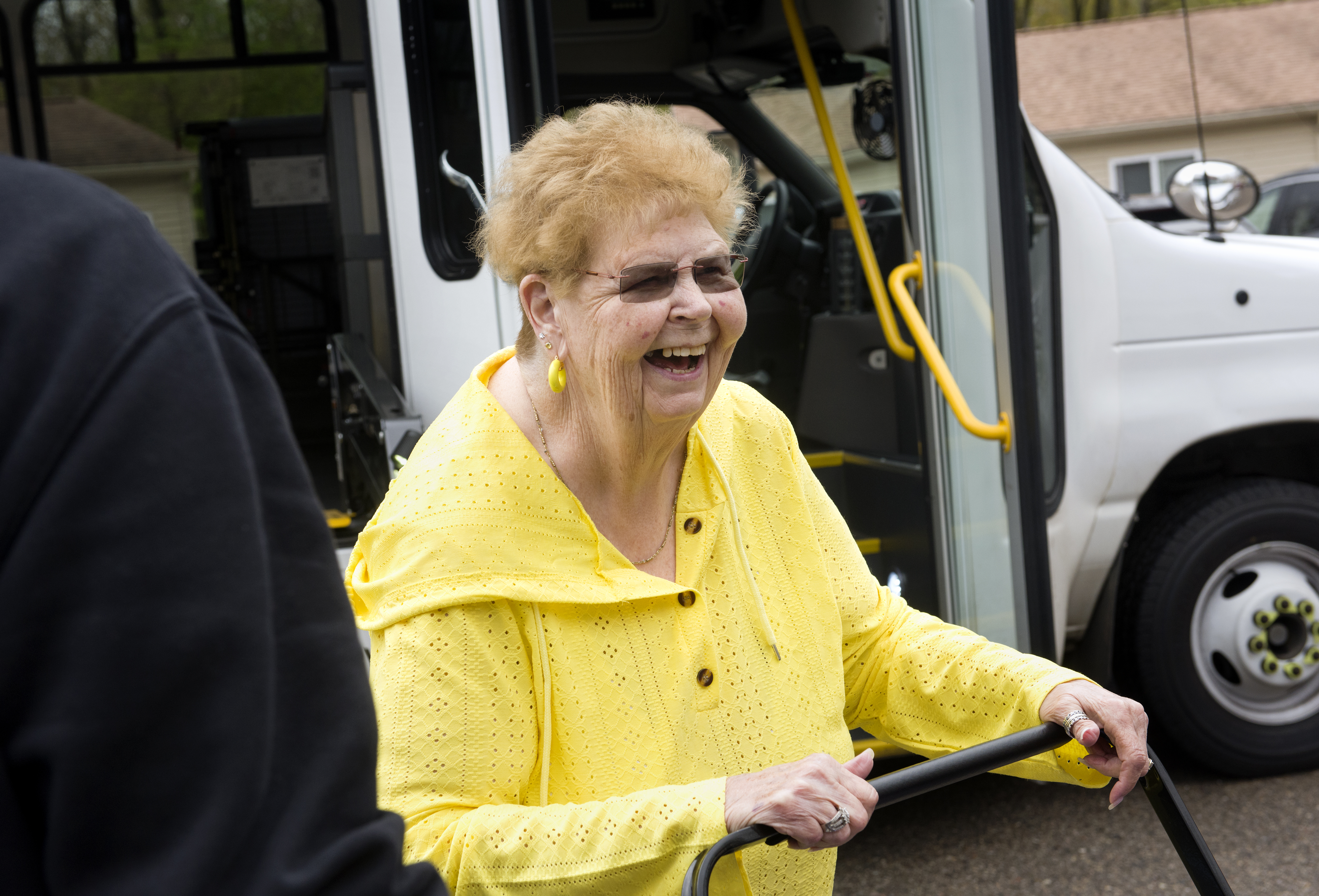 Photo of CATA Ryder outside of vehicle holding onto the handle of a personal shopping cart