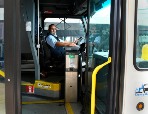 An open CATA bus with smiling driver and farebox