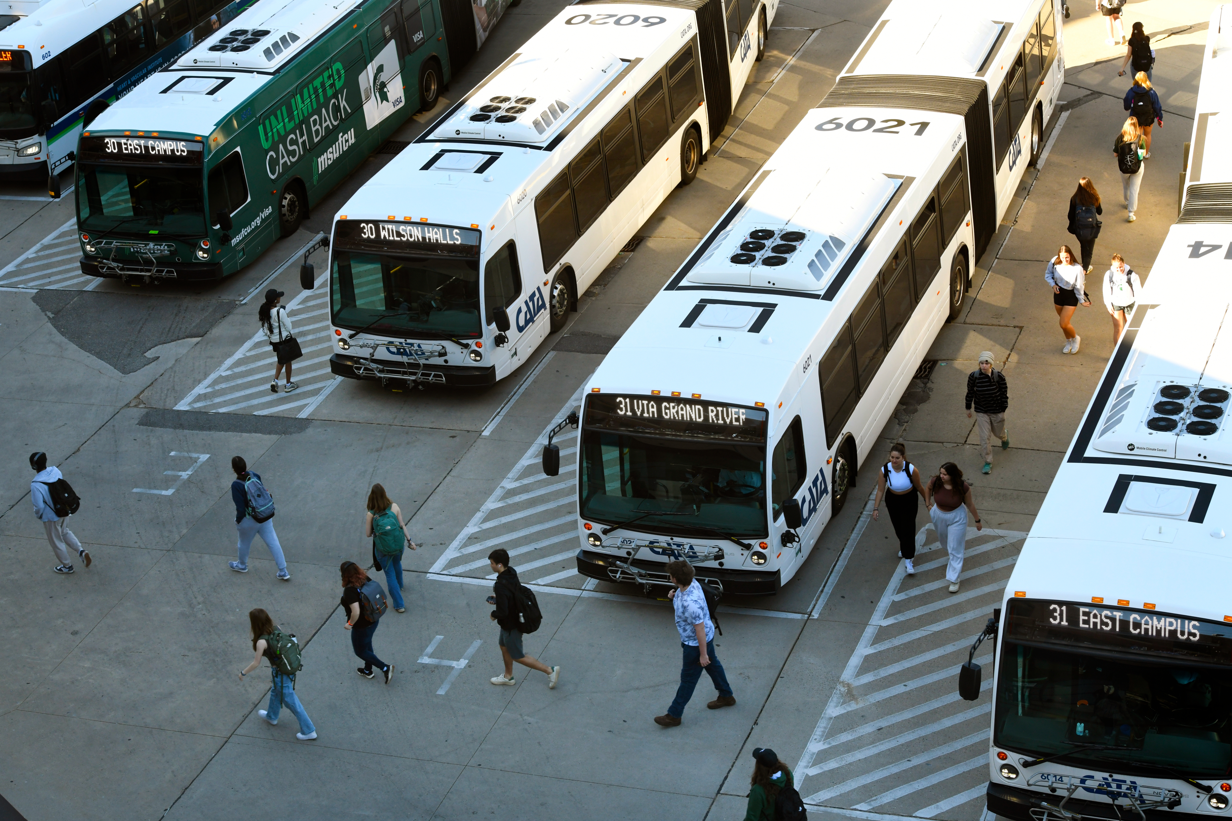 Wide banner showing a diverse group of people standing together and smiling against a green gradient background, representing community events and public participation