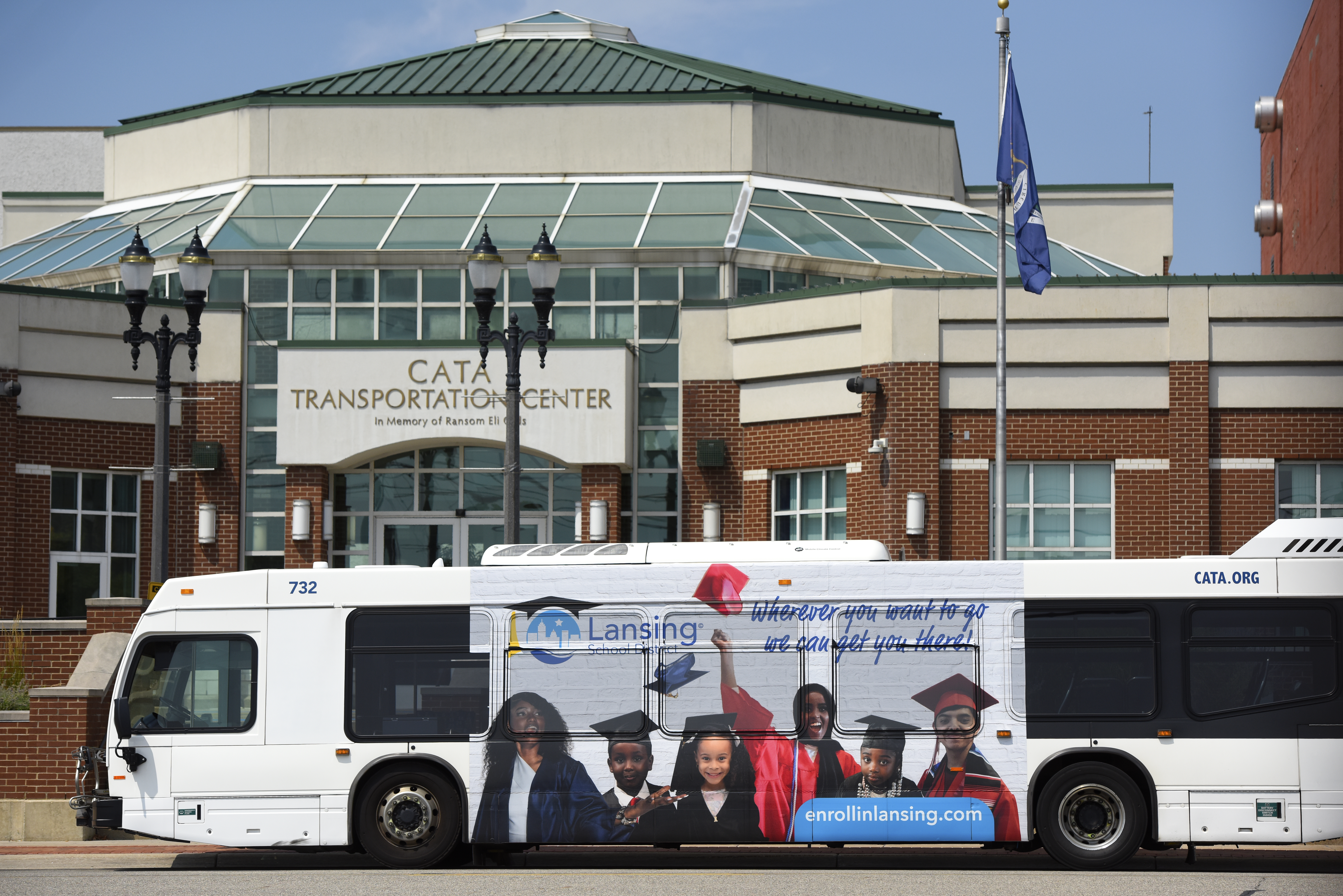 Lansing school district wrapped bus in front of CATA Transportation Center
