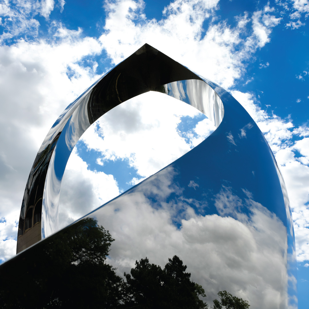A glass sculpture reflecting clouds