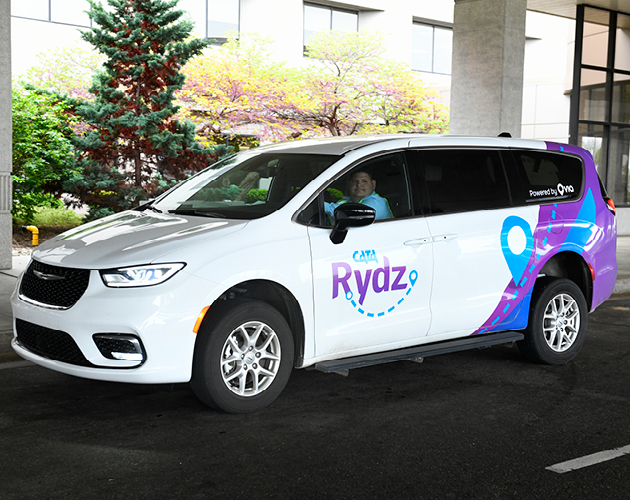 CATA Rydz vehicle parked with a driver smiling at the camera