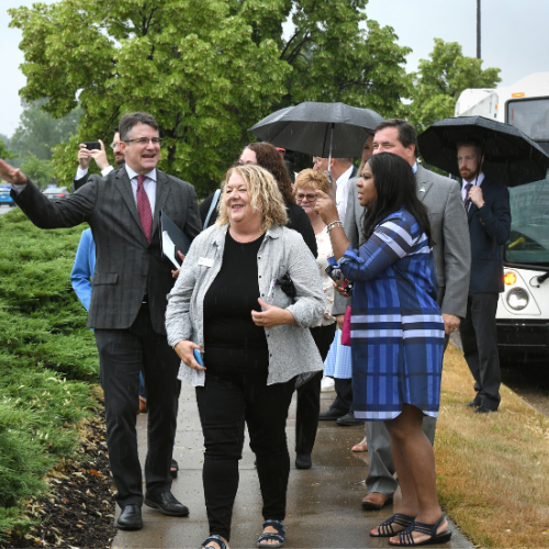 Brad walking and showing people the new route in front of a CATA bus