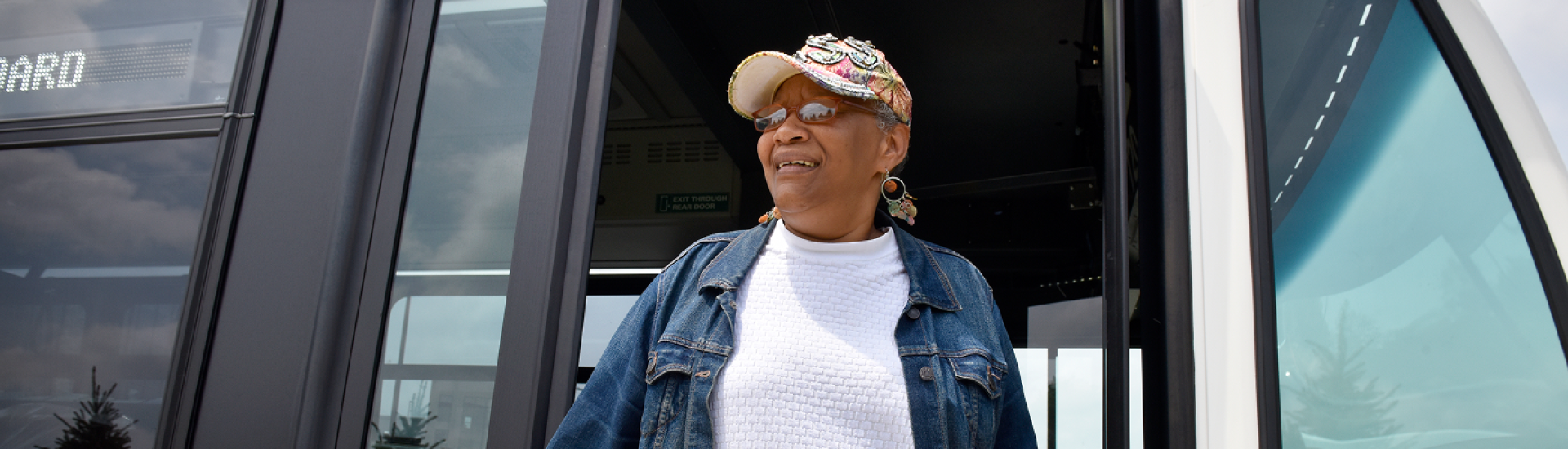 Banner showing older woman in a denim jacket standing in a bus doorway