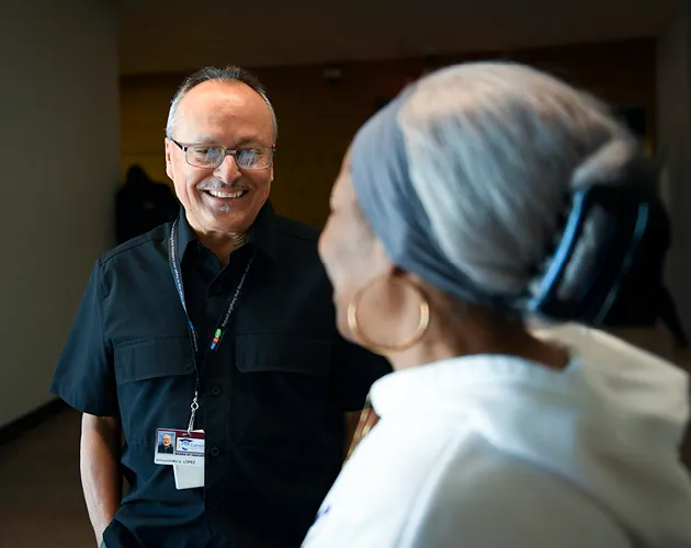 Guillermo Lopez smiling while speaking with another person