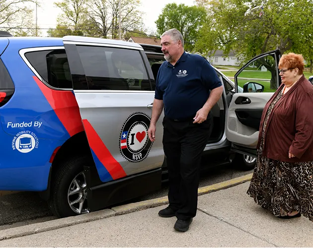 People boarding an RSVP van in a wrap funded by CATA