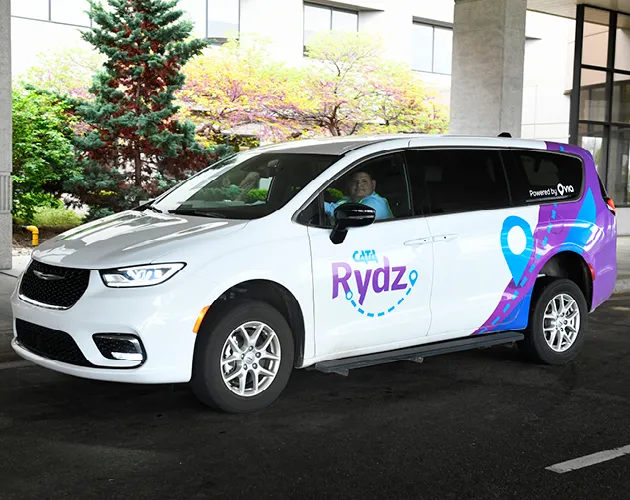 CATA Rydz vehicle parked with a driver smiling at the camera
